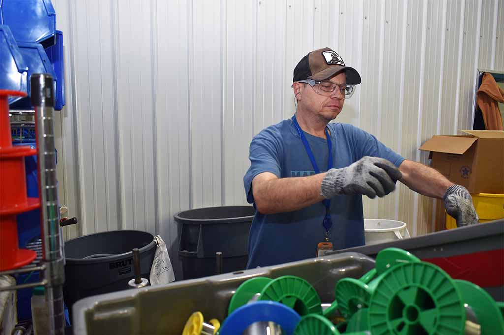 Easterseals Arc Chris pulling wire at Fort Wayne Metals