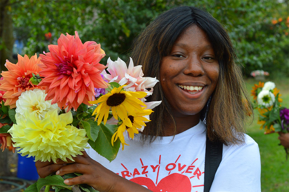 Patricia poses with dahlias and sunflowers